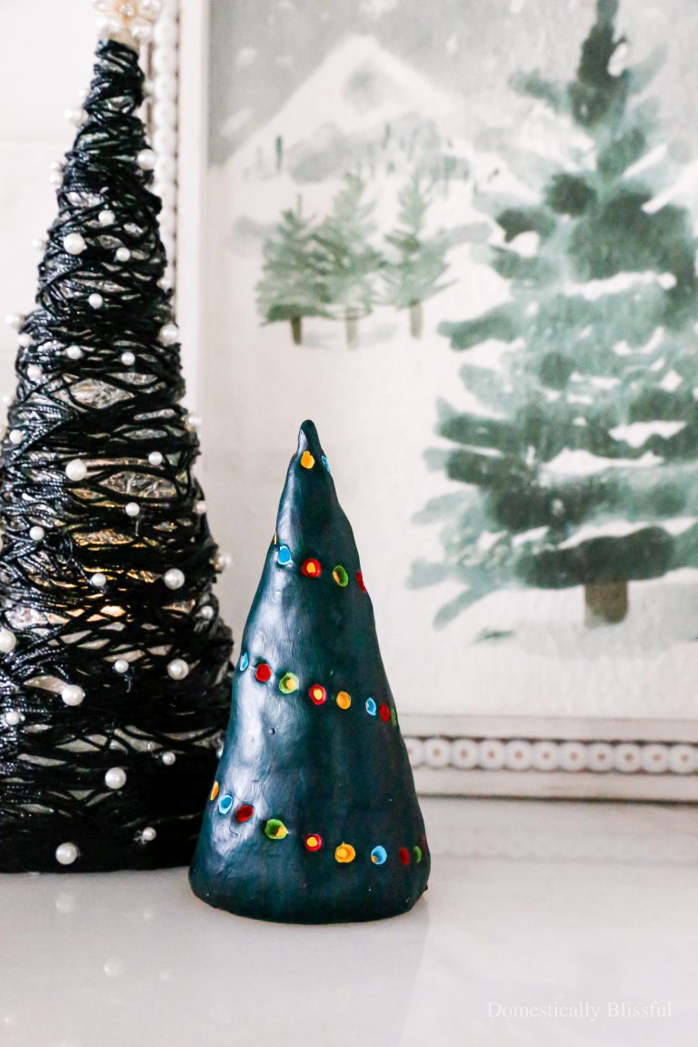 This DIY Clay Christmas Tree Candle Holder hides a flameless candle that shines through colorful Christmas lights.