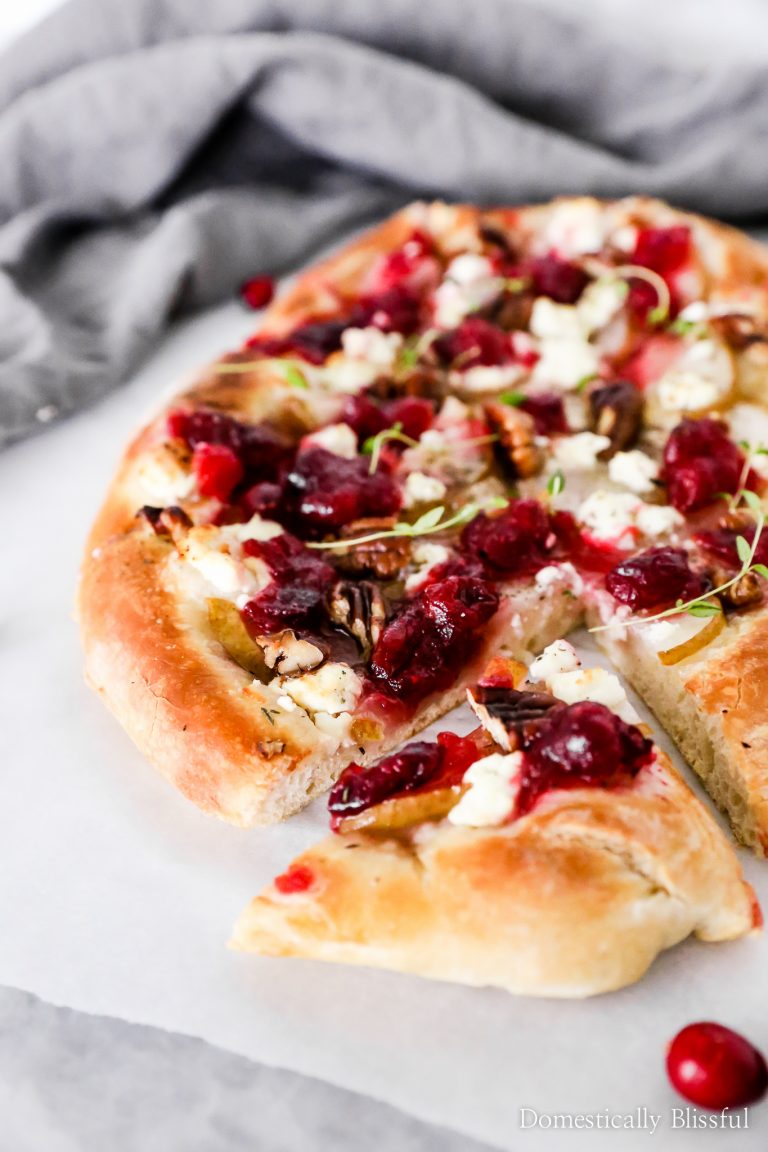 This Cranberry Pear Flatbread is topped with goat cheese, fresh pear, cranberry sauce, and pecans, making it a delicious Thanksgiving leftover recipe.