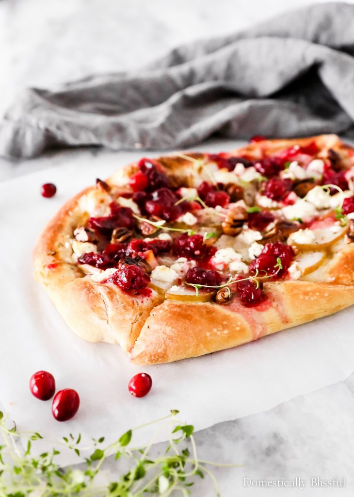 This Cranberry Pear Flatbread is topped with goat cheese, fresh pear, cranberry sauce, and pecans, making it a delicious Christmas appetizer or Thanksgiving leftover recipe.