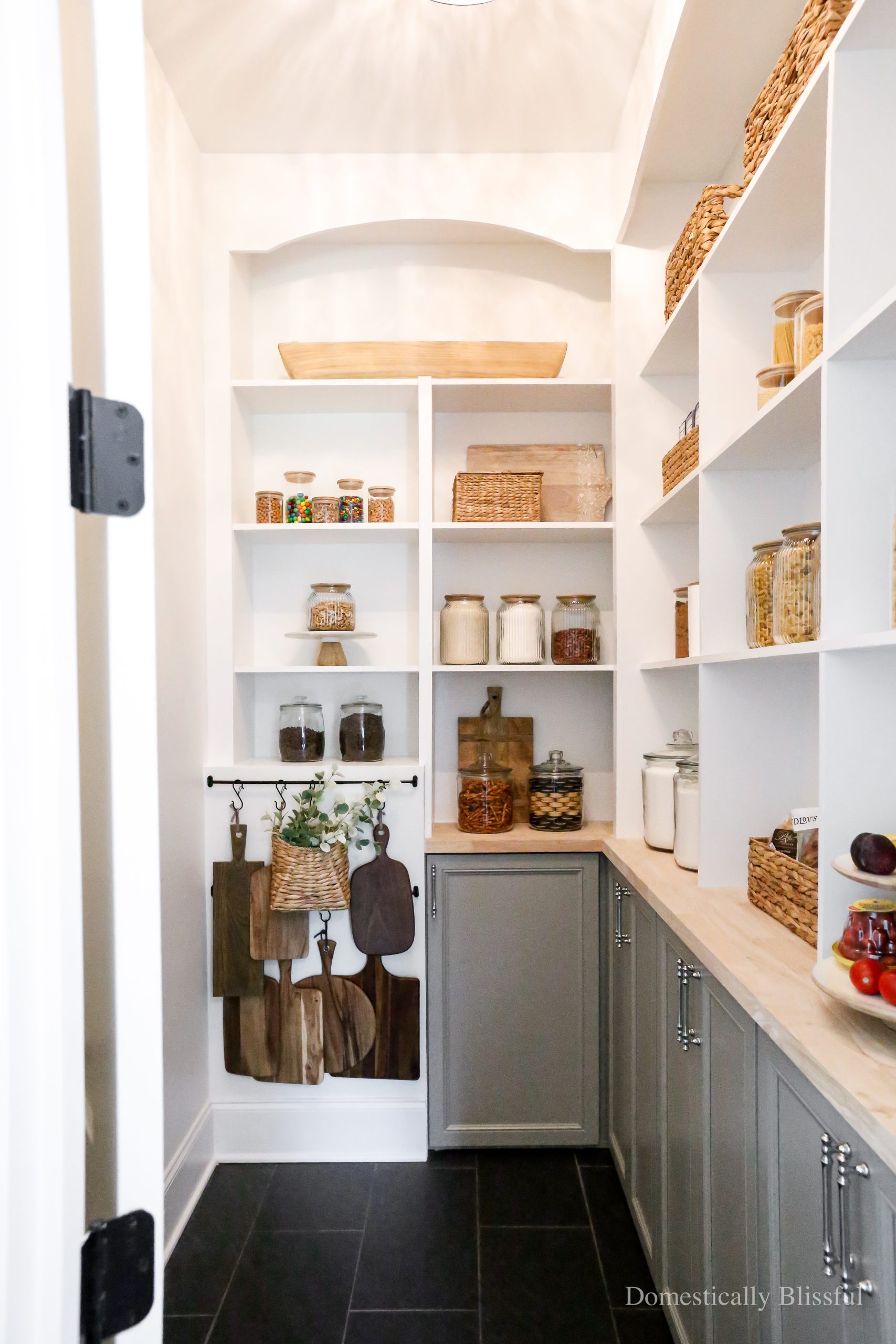 Creating our Dream Pantry Built-Ins with glass storage containers, baskets, and curtain rods for hanging wood cheeseboards.