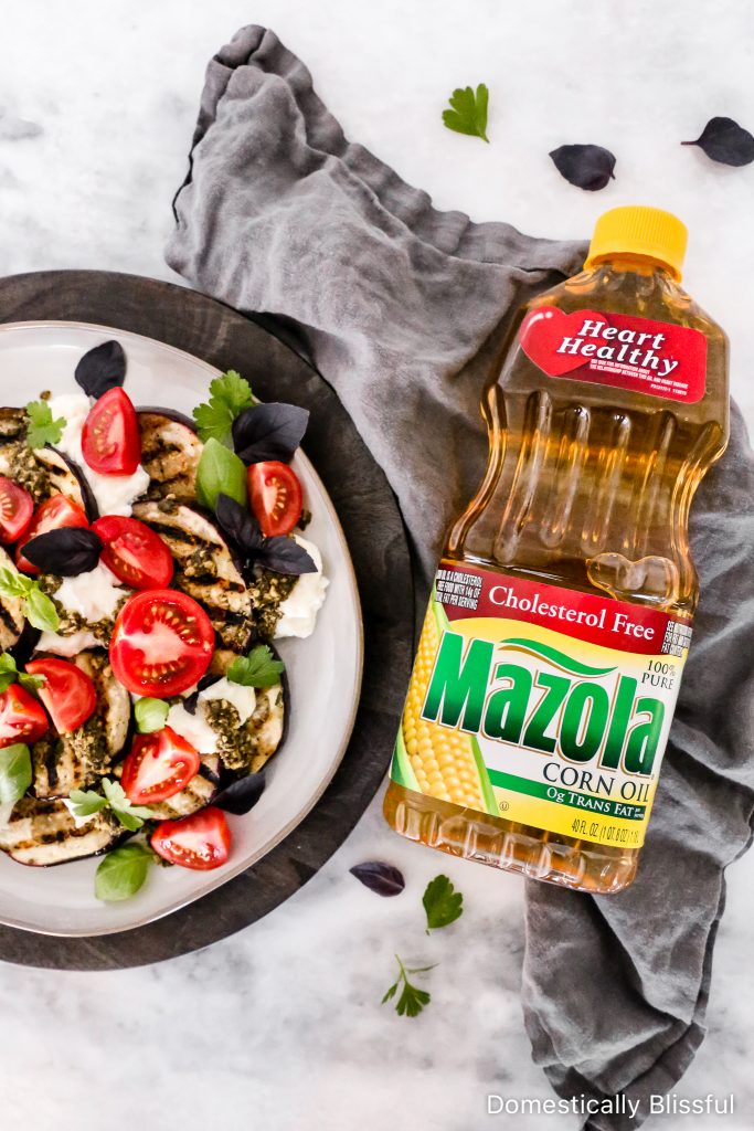 This Grilled Eggplant Salad is marinated, grilled, and topped with whipped ricotta, pesto, quartered tomatoes, and fresh herbs.