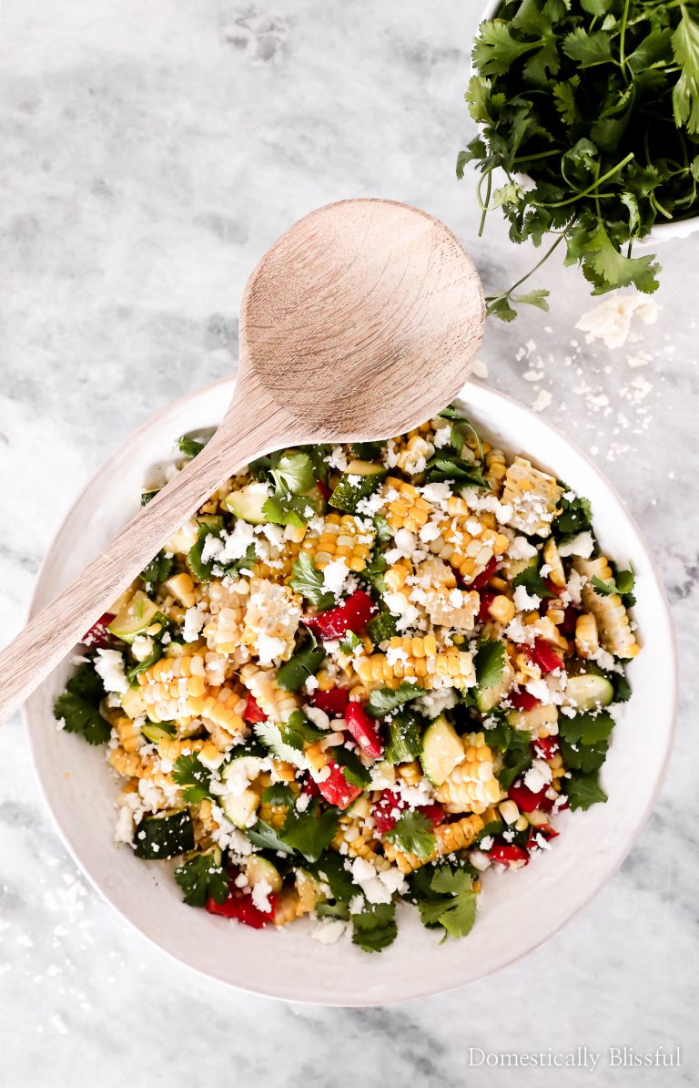This Grilled Summer Corn Salad can be made in your oven & is filled with fresh summer vegetables & topped with a homemade Cilantro Honey Lime Dressing.