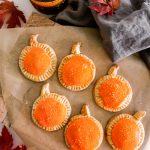 These Homemade Pumpkin Pop Tarts are made with pie crust and have a sweet pumpkin filling topped with orange icing and sprinkles, making them perfect for a fall party or Thanksgiving brunch.