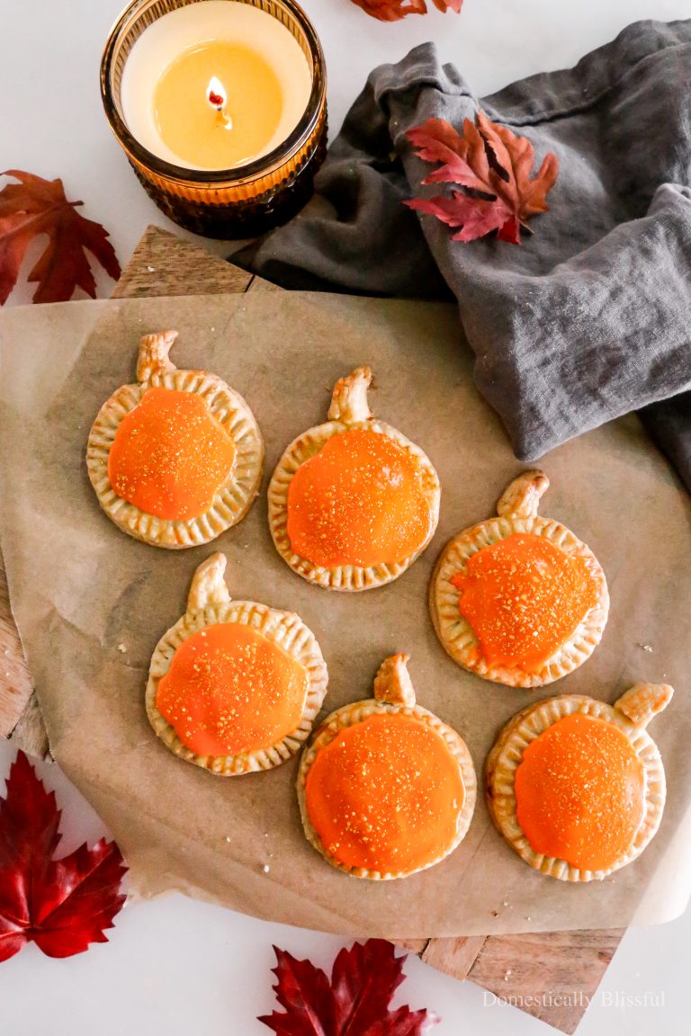 These Homemade Pumpkin Pop Tarts are made with pie crust and have a sweet pumpkin filling topped with orange icing and sprinkles, making them perfect for a fall party or Thanksgiving brunch.