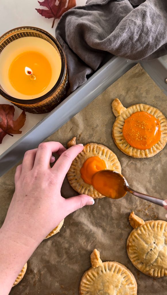 These Homemade Pumpkin Pop Tarts are made with pie crust and have a sweet pumpkin filling topped with orange icing and sprinkles, making them perfect for a fall party or Thanksgiving brunch.