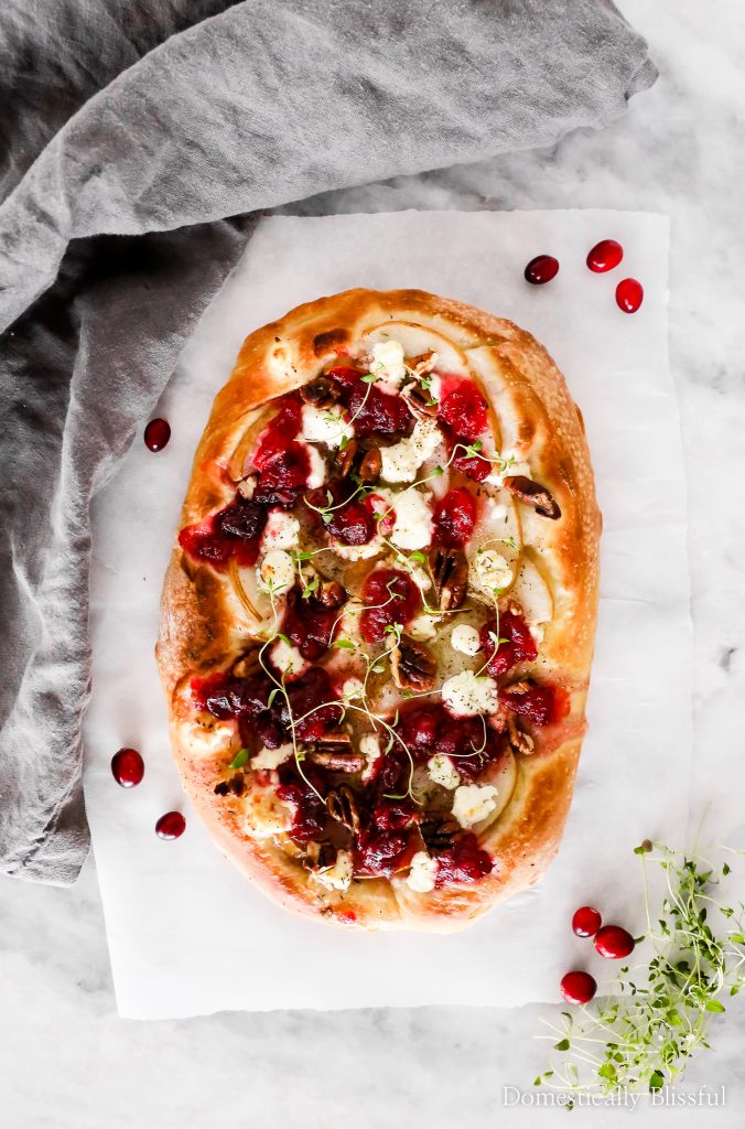 This Cranberry Pear Flatbread is topped with goat cheese, fresh pear, cranberry sauce, and pecans, making it a delicious Christmas appetizer or Thanksgiving leftover recipe.