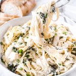 This Spinach Artichoke Fettuccini is made with fresh fettuccini topped with a creamy sauce filled with marinated artichoke hearts and spinach and topped with fresh parsley and grated parmesan.