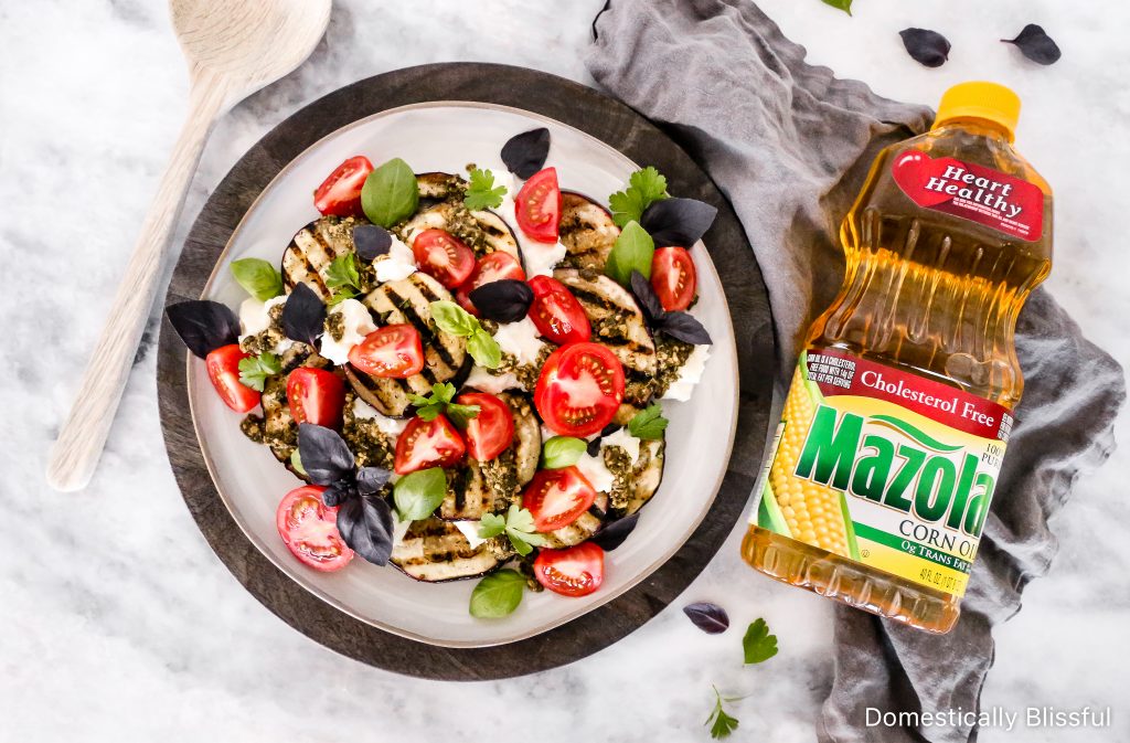 This Grilled Eggplant Salad is marinated, grilled, and topped with whipped ricotta, pesto, quartered tomatoes, and fresh herbs.