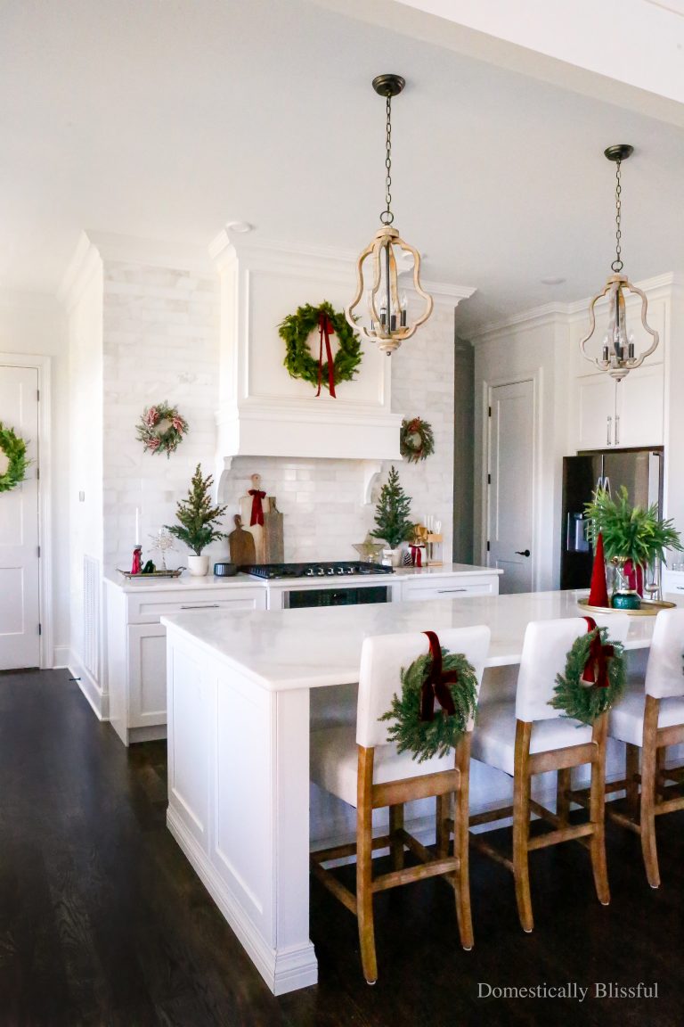 A little tour of our Kitchen Christmas Decor in 2025 with an evergreen and red color scheme in a white kitchen.