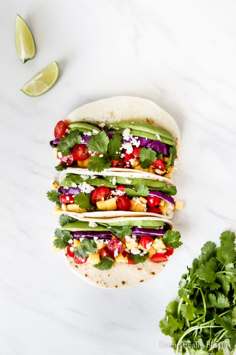 These vegetarian Black Bean Mango Tacos are loaded with fresh ingredients like avocado, red cabbage, & mango!